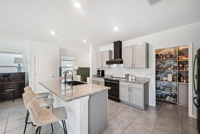 16051 Soft Fern Trce, Odessa, FL 33556 - kitchen featuring black electric range oven, wall chimney exhaust hood, tasteful backsplash, light stone countertops, and a kitchen breakfast bar