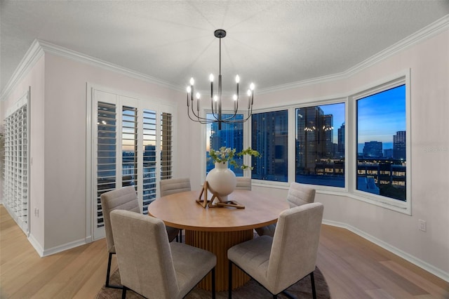 371 Channelside Walk Way Unit 1104, Tampa, FL 33602 - dining space featuring light wood-type flooring, a chandelier, ornamental molding, a skyline view, and a textured ceiling