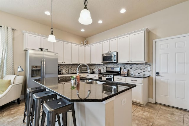 6934 Old Benton Dr, Apollo Beach, FL 33572 - kitchen with stainless steel appliances, backsplash, white cabinetry, a center island with sink, and recessed lighting