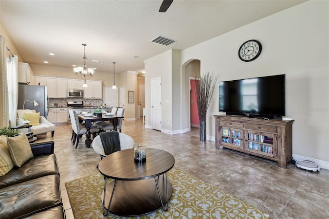 6934 Old Benton Dr, Apollo Beach, FL 33572 - living area featuring arched walkways, light tile patterned floors, a textured ceiling, and ceiling fan