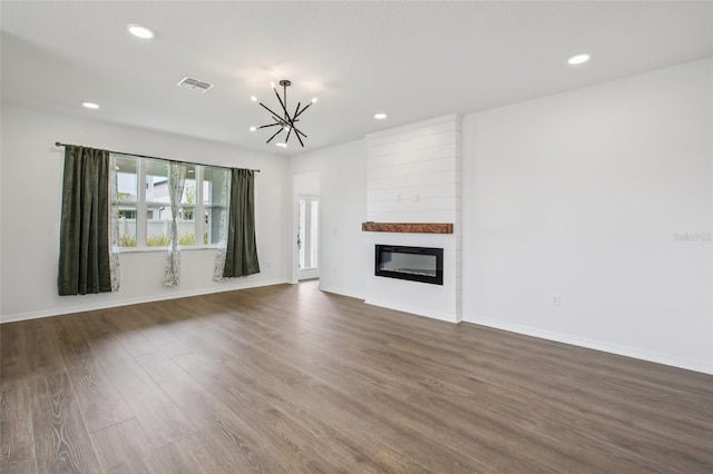 33157 Rosewood Bark Way, Wesley Chapel, FL 33545 - unfurnished living room featuring a chandelier, dark wood-type flooring, recessed lighting, and a large fireplace