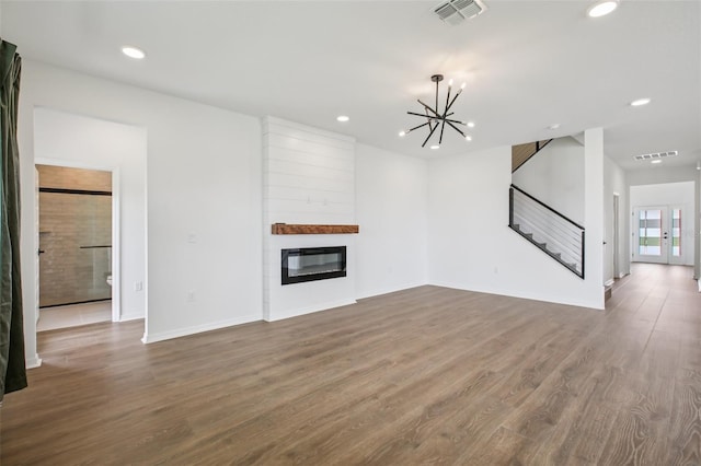 33157 Rosewood Bark Way, Wesley Chapel, FL 33545 - unfurnished living room with a chandelier, stairway, dark wood-type flooring, recessed lighting, and a fireplace
