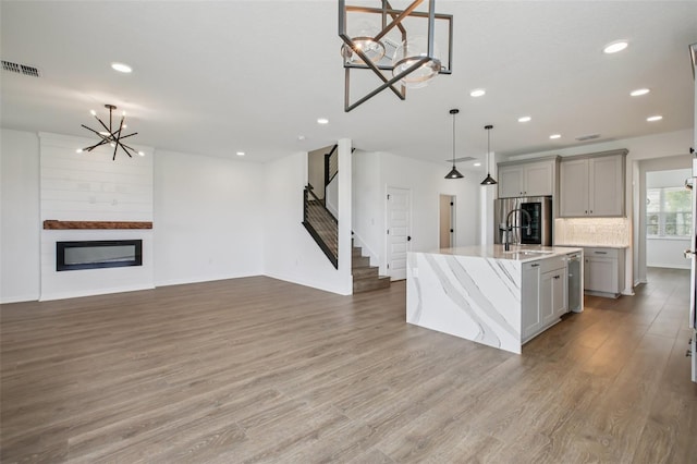 33157 Rosewood Bark Way, Wesley Chapel, FL 33545 - kitchen featuring a chandelier, gray cabinetry, light wood-type flooring, hanging light fixtures, and recessed lighting