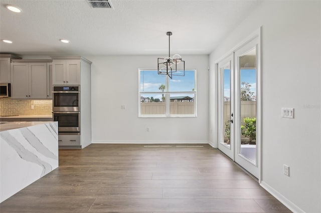 33157 Rosewood Bark Way, Wesley Chapel, FL 33545 - kitchen featuring appliances with stainless steel finishes, gray cabinets, a chandelier, plenty of natural light, and recessed lighting