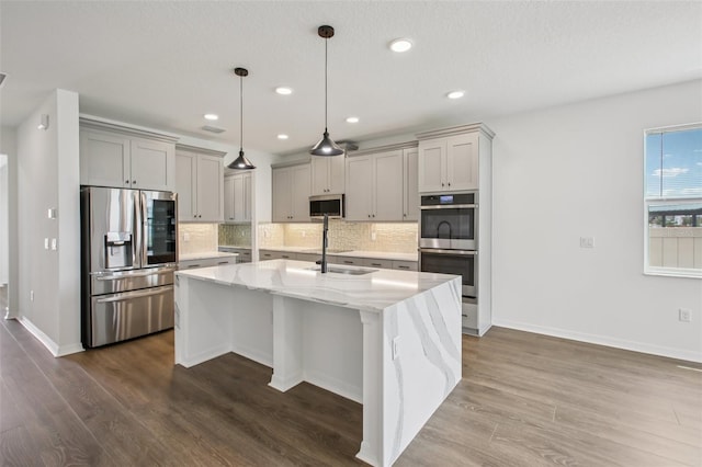 33157 Rosewood Bark Way, Wesley Chapel, FL 33545 - kitchen with stainless steel appliances, gray cabinetry, tasteful backsplash, dark wood finished floors, and recessed lighting