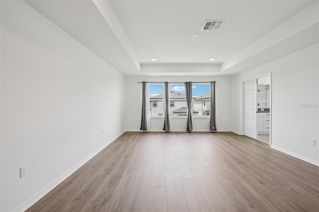 33157 Rosewood Bark Way, Wesley Chapel, FL 33545 - unfurnished room featuring a tray ceiling, wood finished floors, and recessed lighting