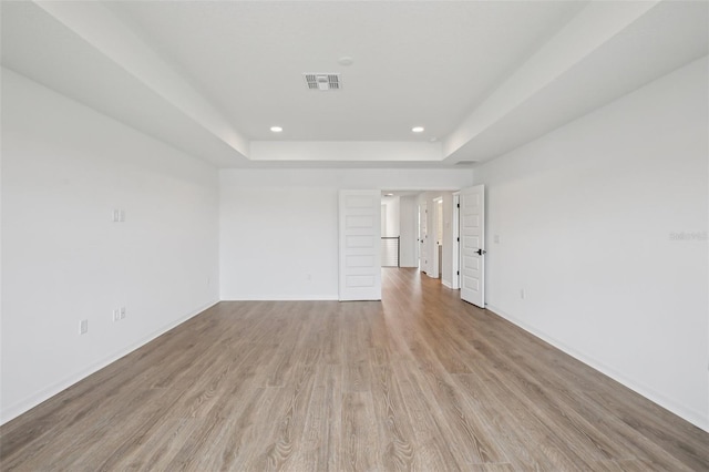 33157 Rosewood Bark Way, Wesley Chapel, FL 33545 - spare room with a raised ceiling, light wood finished floors, and recessed lighting