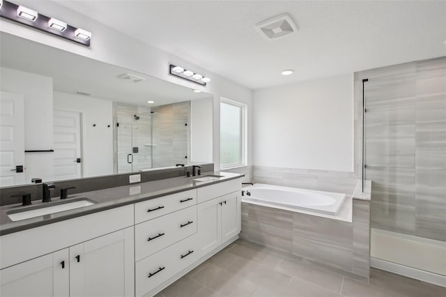 33157 Rosewood Bark Way, Wesley Chapel, FL 33545 - bathroom featuring a stall shower, double vanity, a garden tub, tile patterned floors, and recessed lighting