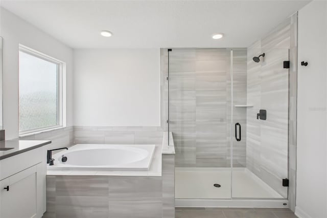 33157 Rosewood Bark Way, Wesley Chapel, FL 33545 - full bathroom featuring a garden tub, vanity, a stall shower, tile patterned flooring, and recessed lighting