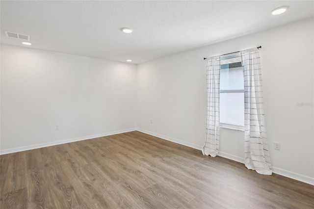 33157 Rosewood Bark Way, Wesley Chapel, FL 33545 - unfurnished room with wood finished floors and recessed lighting