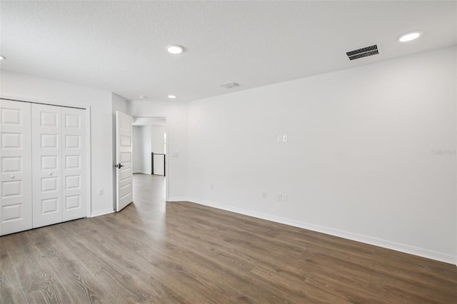 33157 Rosewood Bark Way, Wesley Chapel, FL 33545 - unfurnished bedroom with wood finished floors, recessed lighting, and a closet