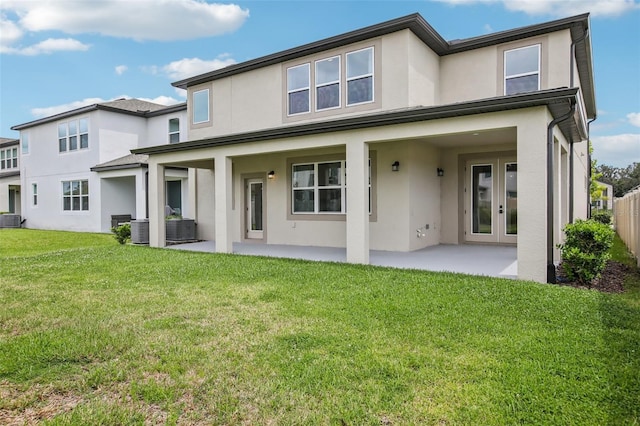 33157 Rosewood Bark Way, Wesley Chapel, FL 33545 - back of house with stucco siding, a patio area, and a yard