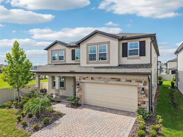 33157 Rosewood Bark Way, Wesley Chapel, FL 33545 - view of front of property with stucco siding, stone siding, an attached garage, decorative driveway, and roof with shingles