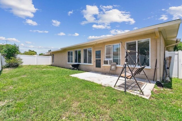 8030 San Bernardino Dr, Port Richey, FL 34668 - rear view of house featuring stucco siding, a patio, and a fenced backyard
