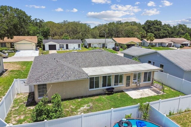 8030 San Bernardino Dr, Port Richey, FL 34668 - rear view of property featuring a residential view, stucco siding, roof with shingles, a patio area, and a fenced backyard