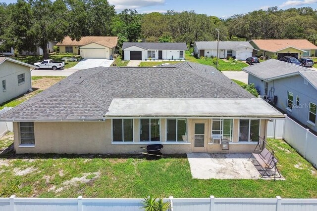 8030 San Bernardino Dr, Port Richey, FL 34668 - back of house featuring a residential view, a fenced backyard, stucco siding, and roof with shingles