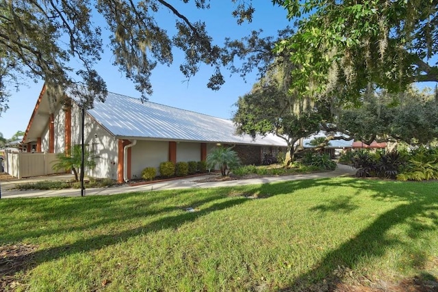 8030 San Bernardino Dr, Port Richey, FL 34668 - view of front of home featuring a front yard and a metal roof