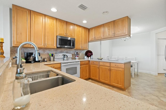 7296 Marathon Dr Unit 603, Seminole, FL 33777 - kitchen with stainless steel microwave, white electric range, decorative backsplash, light stone counters, and recessed lighting