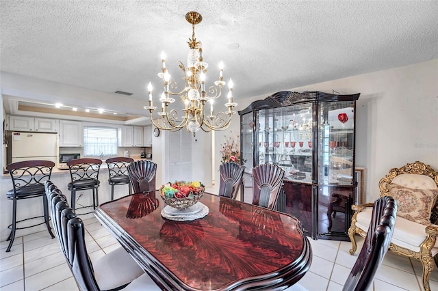 2182 Corinne Ct S Unit C, Saint Petersburg, FL 33712 - dining area featuring a chandelier, light tile patterned floors, and a textured ceiling