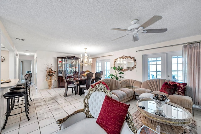 2182 Corinne Ct S Unit C, Saint Petersburg, FL 33712 - living area featuring french doors, a chandelier, a textured ceiling, light tile patterned floors, and a ceiling fan