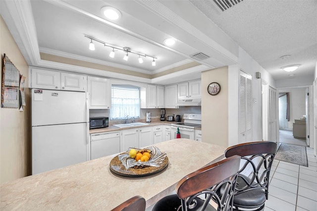 2182 Corinne Ct S Unit C, Saint Petersburg, FL 33712 - kitchen featuring white appliances, under cabinet range hood, ornamental molding, light tile patterned floors, and white cabinets