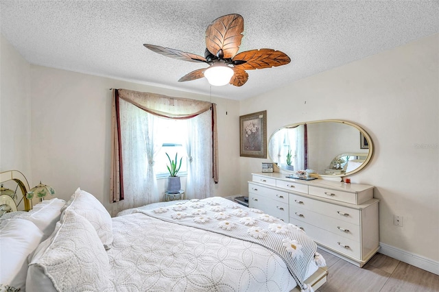 2182 Corinne Ct S Unit C, Saint Petersburg, FL 33712 - bedroom featuring light wood-style flooring, a textured ceiling, and ceiling fan