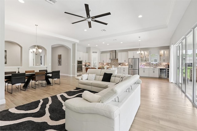5426 Wayfarer Ave, Apollo Beach, FL 33572 - living room with beverage cooler, arched walkways, a chandelier, light wood finished floors, and recessed lighting