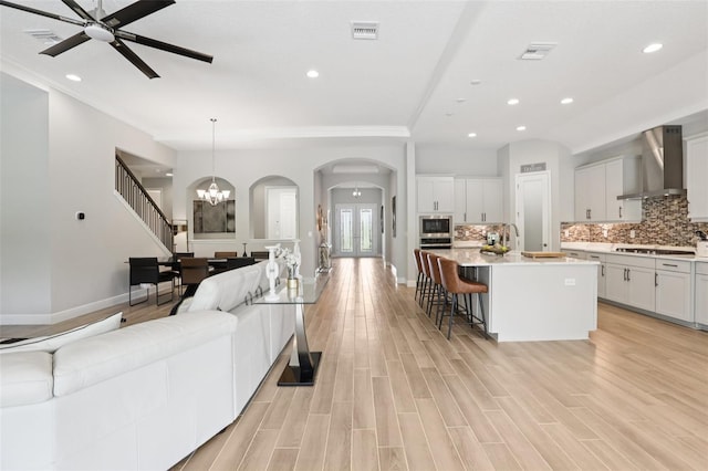 5426 Wayfarer Ave, Apollo Beach, FL 33572 - living area featuring arched walkways, ornamental molding, ceiling fan, recessed lighting, and light wood-style floors