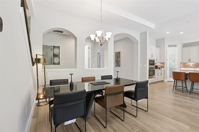 5426 Wayfarer Ave, Apollo Beach, FL 33572 - dining area featuring light wood finished floors, a chandelier, recessed lighting, and arched walkways