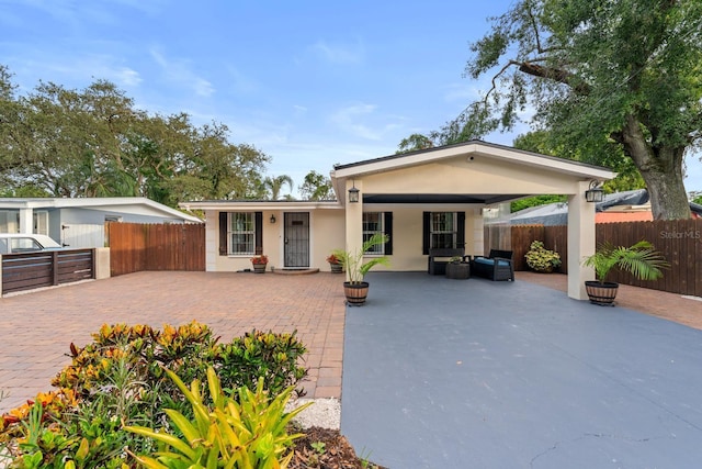 1905 E 99th Ave, Tampa, FL 33612 - view of front facade featuring a patio area, an outdoor living space, and stucco siding
