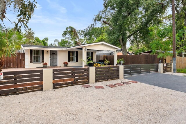 1905 E 99th Ave, Tampa, FL 33612 - view of front of home with a fenced front yard, a porch, and stucco siding