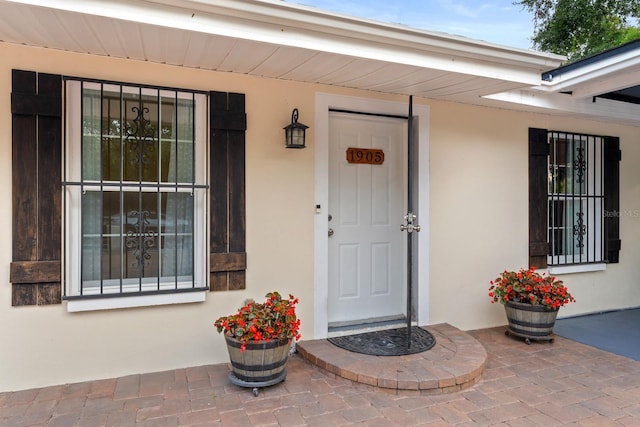 1905 E 99th Ave, Tampa, FL 33612 - doorway to property featuring stucco siding and covered porch