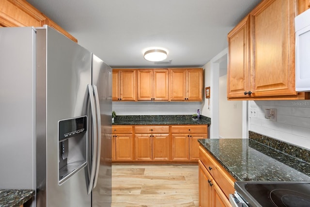 1905 E 99th Ave, Tampa, FL 33612 - kitchen with appliances with stainless steel finishes, light wood-style floors, backsplash, dark stone countertops, and brown cabinets