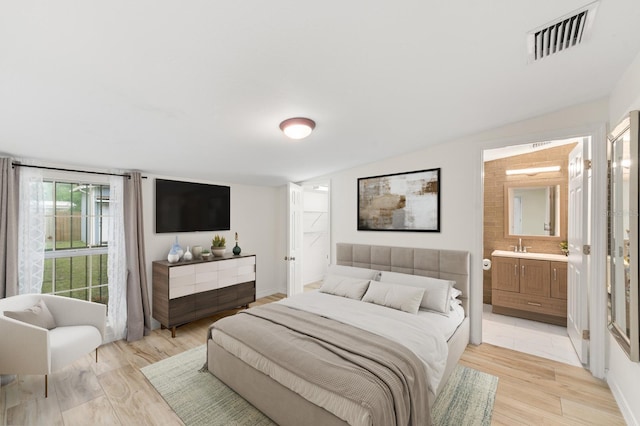 1905 E 99th Ave, Tampa, FL 33612 - bedroom featuring light wood-type flooring, connected bathroom, and lofted ceiling