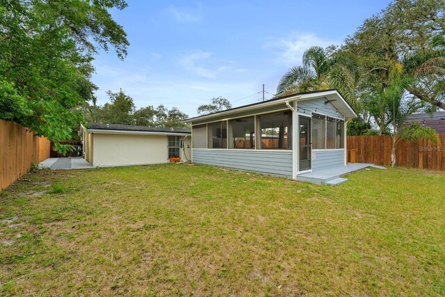 1905 E 99th Ave, Tampa, FL 33612 - rear view of house with a fenced backyard and a sunroom