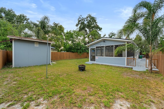 1905 E 99th Ave, Tampa, FL 33612 - fenced backyard featuring a sunroom, a fire pit, and an outdoor structure