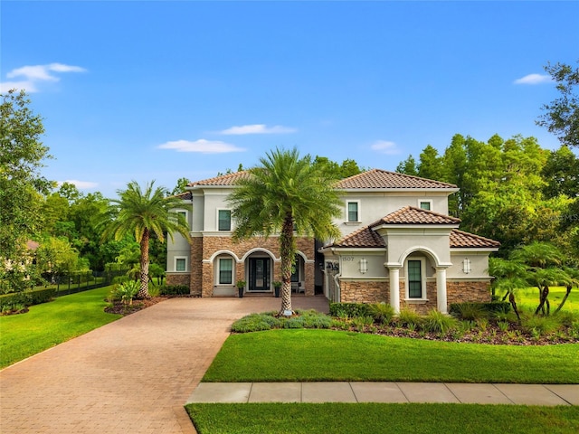 1507 Amarone Pl, Lutz, FL 33548 - mediterranean / spanish-style home with stucco siding, decorative driveway, stone siding, and a tile roof