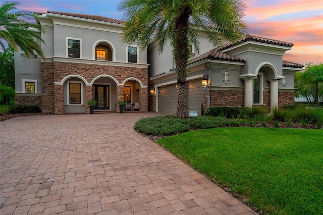 1507 Amarone Pl, Lutz, FL 33548 - mediterranean / spanish home featuring stucco siding, decorative driveway, stone siding, a tiled roof, and a yard