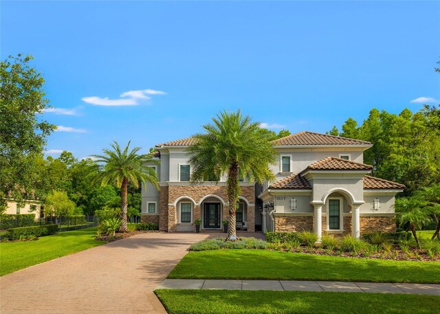 1507 Amarone Pl, Lutz, FL 33548 - mediterranean / spanish house with stone siding, decorative driveway, stucco siding, and a tiled roof