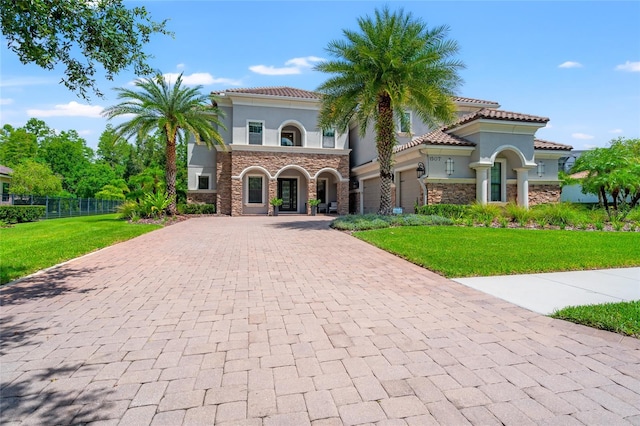 1507 Amarone Pl, Lutz, FL 33548 - mediterranean / spanish house featuring decorative driveway, stucco siding, and stone siding