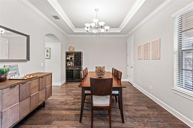 1507 Amarone Pl, Lutz, FL 33548 - dining room with a chandelier, arched walkways, a tray ceiling, dark wood-type flooring, and ornamental molding