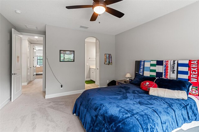 1507 Amarone Pl, Lutz, FL 33548 - bedroom featuring light carpet, arched walkways, attic access, a ceiling fan, and ensuite bath