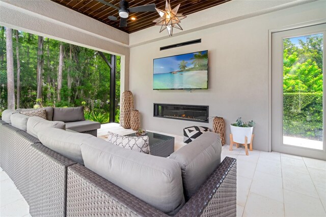 1507 Amarone Pl, Lutz, FL 33548 - living room featuring plenty of natural light, a glass covered fireplace, ceiling fan, and tile patterned flooring