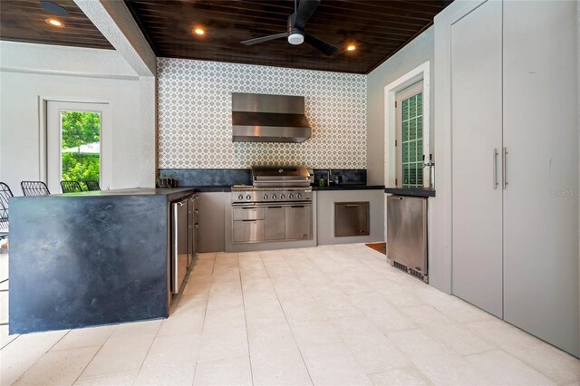 1507 Amarone Pl, Lutz, FL 33548 - kitchen with wall chimney range hood, refrigerator, dark countertops, ceiling fan, and decorative backsplash