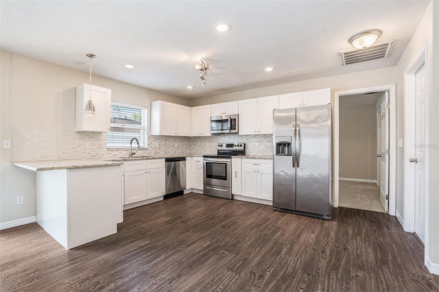 6601 N Elizabeth St, Tampa, FL 33604 - kitchen with stainless steel appliances, dark wood-type flooring, white cabinetry, tasteful backsplash, and recessed lighting