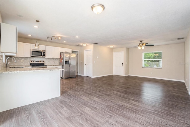 6601 N Elizabeth St, Tampa, FL 33604 - kitchen with stainless steel appliances, ceiling fan, light stone countertops, decorative backsplash, and white cabinets