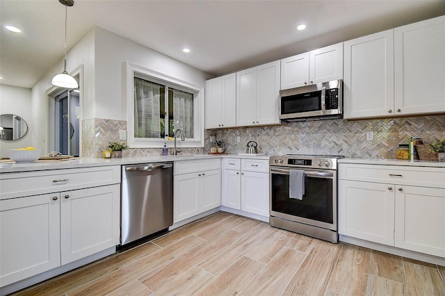 10900 65th Way N, Pinellas Park, FL 33782 - kitchen featuring appliances with stainless steel finishes, light countertops, white cabinets, decorative backsplash, and recessed lighting