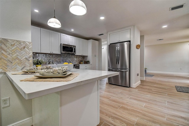 10900 65th Way N, Pinellas Park, FL 33782 - kitchen featuring appliances with stainless steel finishes, light countertops, tasteful backsplash, a peninsula, and recessed lighting