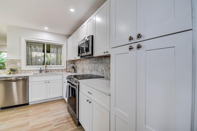 10900 65th Way N, Pinellas Park, FL 33782 - kitchen featuring stainless steel appliances, light countertops, backsplash, white cabinetry, and recessed lighting