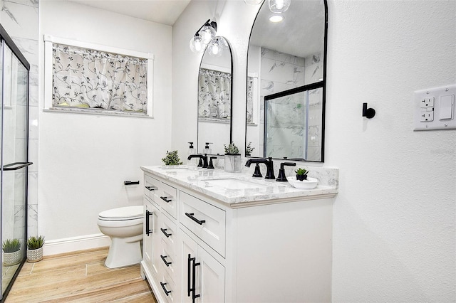 10900 65th Way N, Pinellas Park, FL 33782 - bathroom featuring a marble finish shower, double vanity, and wood finished floors